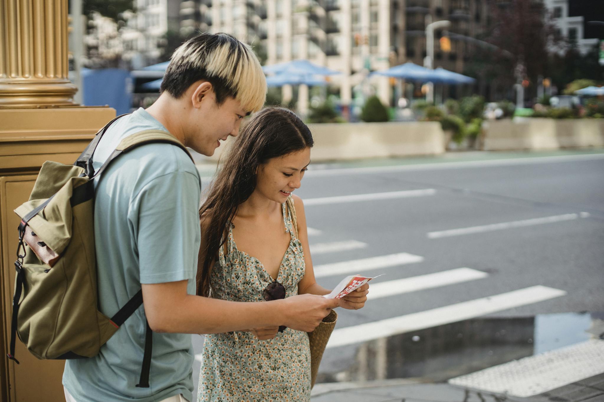 Traveling couple standing on sidewalk with map